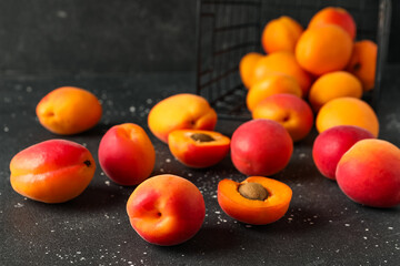 Basket with sweet apricots on black background
