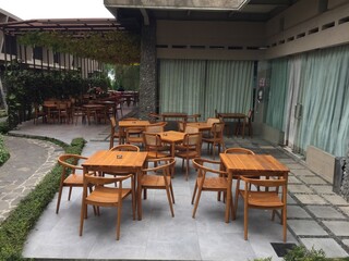 Outdoor Patio Seating Area with Wooden Tables and Chairs
