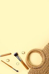 Composition with makeup brushes, earrings and female bag on color background