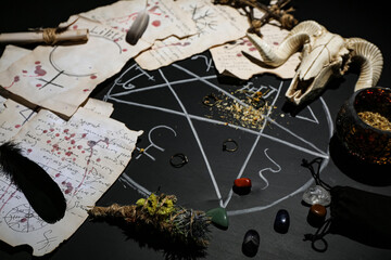 Witch's magic attributes with drawn pentagram on dark background