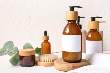 Bottles of shampoo, brush and cosmetic products on white background