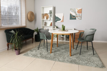 Beautiful living room with table, black cozy sofa and shelving unit
