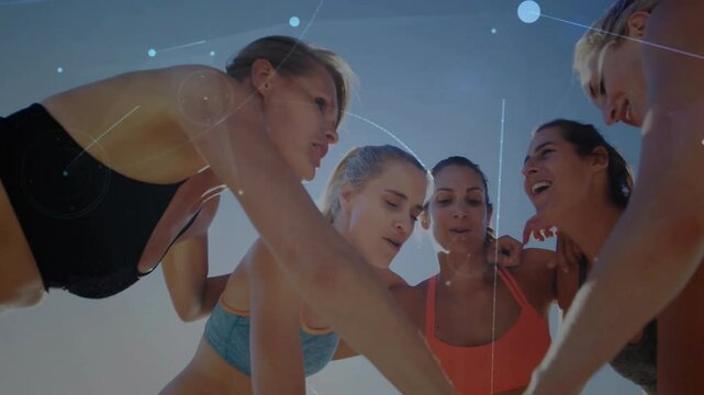 Women athletes leaning inward starting volleyball hand stacking for team unity with digital nodes