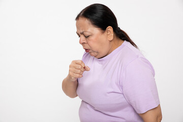 Indian senior unhealthy woman chest pain while dry cough against grey background 