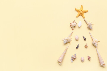Starfish and shells in shape of Christmas tree on beige background. Top view