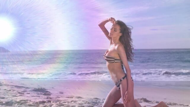 Sun shining swimsuit fashion model kneeling shore arching back posing in striped bikini with flare
