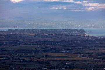 An aerial view shows the city of Napier, New Zealand, nestled between the Pacific Ocean and the Hawke's Bay wine region. The image highlights the region's unique geography.