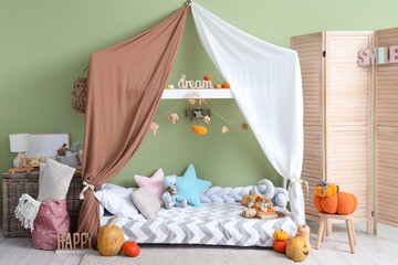 Interior of children's room with bed, toys and pumpkins
