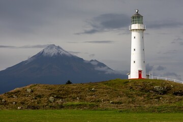 Cape Egmont Lighthouse stands tall on the coast of Pungarehu, Taranaki, New Zealand, guiding ships...