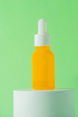 Plastic yellow tube for cream or lotion. Skin care or sunscreen cosmetic with stylish props on green background.