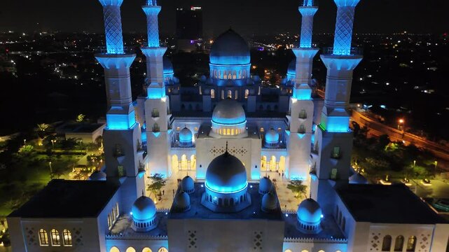 A breathtaking aerial night photograph of the Sheikh Zayed Grand Mosque located in Solo (Surakarta), Central Java, Indonesia. This stunning image captures the mosque&rsquo;s majestic white domes and four to