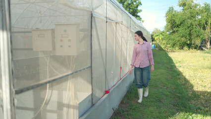 Young people examining plants in a greenhouse, learning about sustainable farming