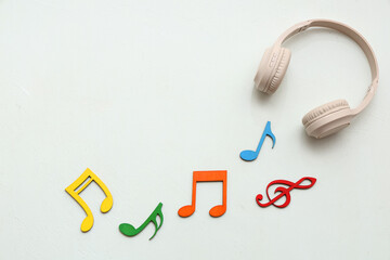 Composition with headphones and decorative music notes on white background