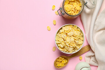 Composition with bowl and jar of tasty cornflakes on pink background
