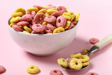 Bowl of tasty color cereal rings on pink background, closeup