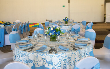 A blue and white table setting with a vase of flowers and a bowl of fruit