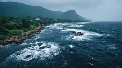Rocky shoreline meets a vast ocean under a cloudy sky.
