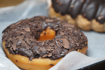 Chocolate donut topped with flakes on display