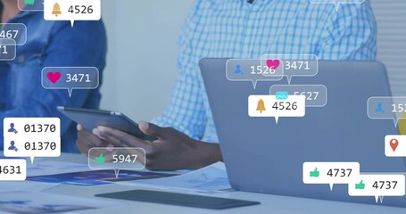 When social media icons popping up around laptop, coworkers tracking rising engagement on tablet - Powered by Adobe