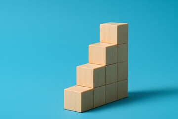 Wooden blocks stacked in ascending steps on blue background