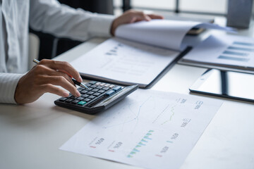 Businessman Calculating Finances with Calculator in Modern Office.