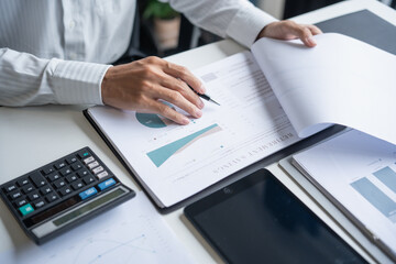 Professional Reviewing Business Data and Using Calculator.