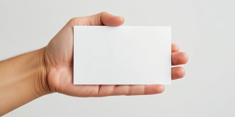 Person's hand presenting a clean, empty white card with ample space for custom text, perfect for various professional or personal uses.