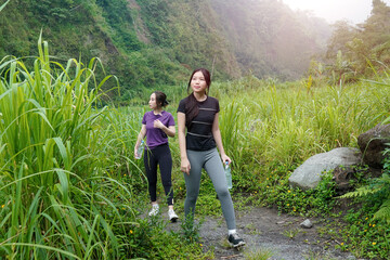 Asian Women Hiking in Lush Green Valley, Embracing Sport, Exercise, Sustainable Outdoor Lifestyles