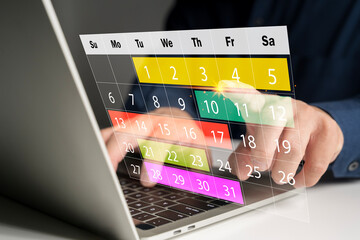 Digital calendar interface on laptop screen with hand pointing at date for planning, schedule, and reminder
