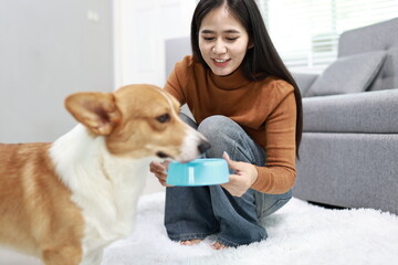 A cheerful young woman works from home, smiling warmly as her cute labrador sits beside her, bringing comfort, companionship, and joy.