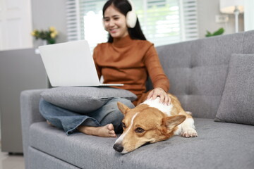 A cheerful young woman works from home, smiling warmly as her cute labrador sits beside her, bringing comfort, companionship, and joy.