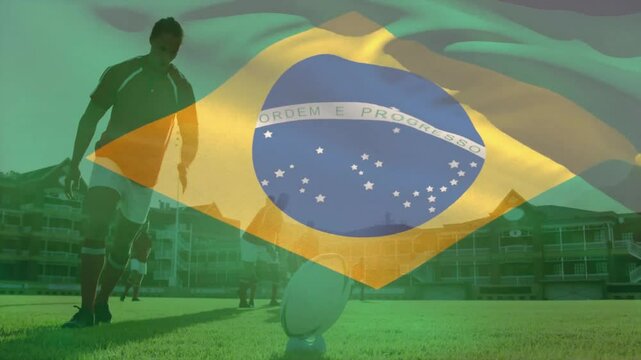 Male player approaching ball on training pitch drawing leg kicking ball while Brazilian flag waving