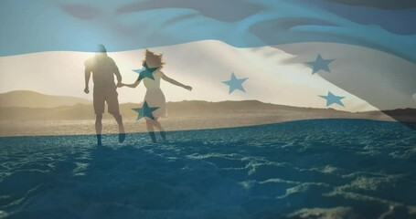 Drifting Honduras flag revealing silhouettes, couple joining hands walking beach sunset for tourism - Powered by Adobe