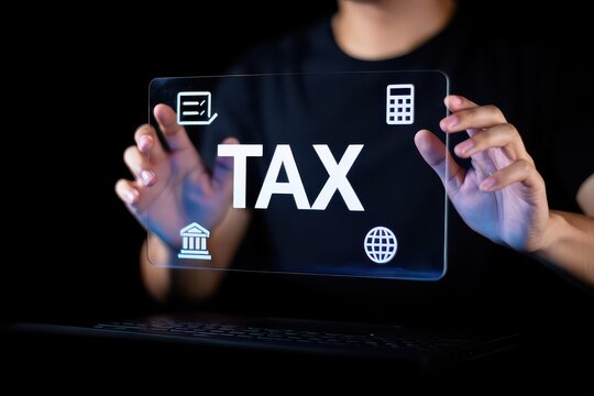Person Holding Transparent Screen Displaying Tax Concept with Icons on Black Background