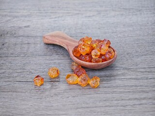 Peach gum in wooden spoon.