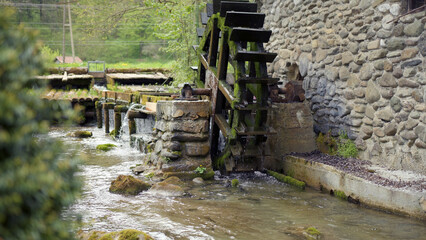 Old water mill with wheel on the river.