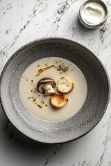 Creamy Mushroom Soup with Croutons and Drizzle on a Marble Surface