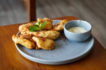 Crispy Fried Banana, Indonesia, captured on June 12, 2025. Traditional snack made from ripe bananas coated in crispy batter, topped with grated palm sugar for a sweet and crunchy finish.