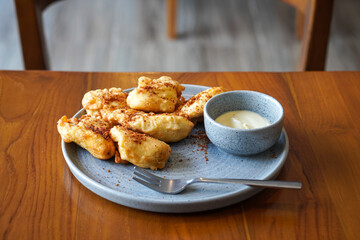 Crispy Fried Banana, Indonesia, captured on June 12, 2025. Traditional snack made from ripe bananas coated in crispy batter, topped with grated palm sugar for a sweet and crunchy finish.