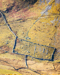 Aerial view of rectangular stone-walled Roman ruins in the hills of the Lake District National Park, England, with visible field boundaries and ancient infrastructure