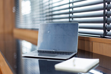 Laptop with blank copy space screen on table with stationery on table against white wall....