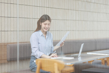  Portrait of young business woman using a calculator to check company finances and earnings and...