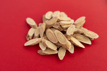 Astragalus membranaceus, a traditional Chinese medicine, on a red background