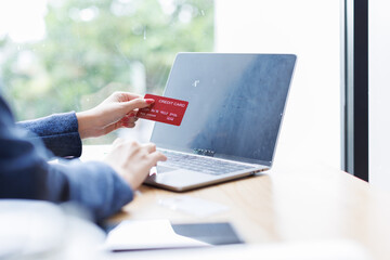 Transfer money online using bank payment card. young asian woman Hands input credit card data using...