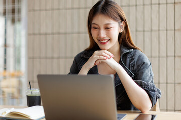 Happy young asian girl learn english language online with computer laptop.discussing a project, and...