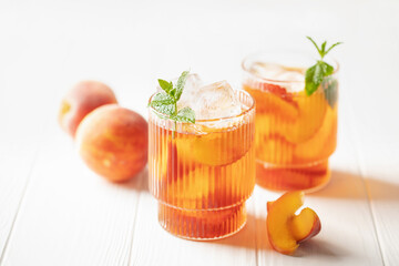 Peaches iced tea  in a glass on the table. Summer drink concept