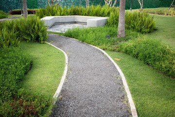 Walkway and landscape in garden, park. Also called path, footpath, pathway or asphalt floor. Include concrete bench, natural plant, bush, lawn and grass. Landscaping decoration of outdoor.