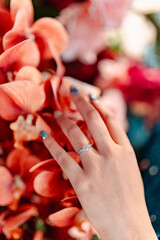 woman hand with engagement ring touch a flowers