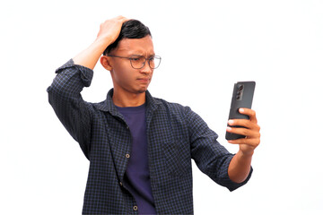An Asian man shows a sad expression while holding a cellphone.