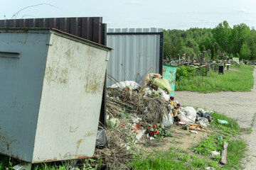 Overflowing Trash Bin at Cemetery. A Silent Witness to Forgotten Memories and Neglect. The...